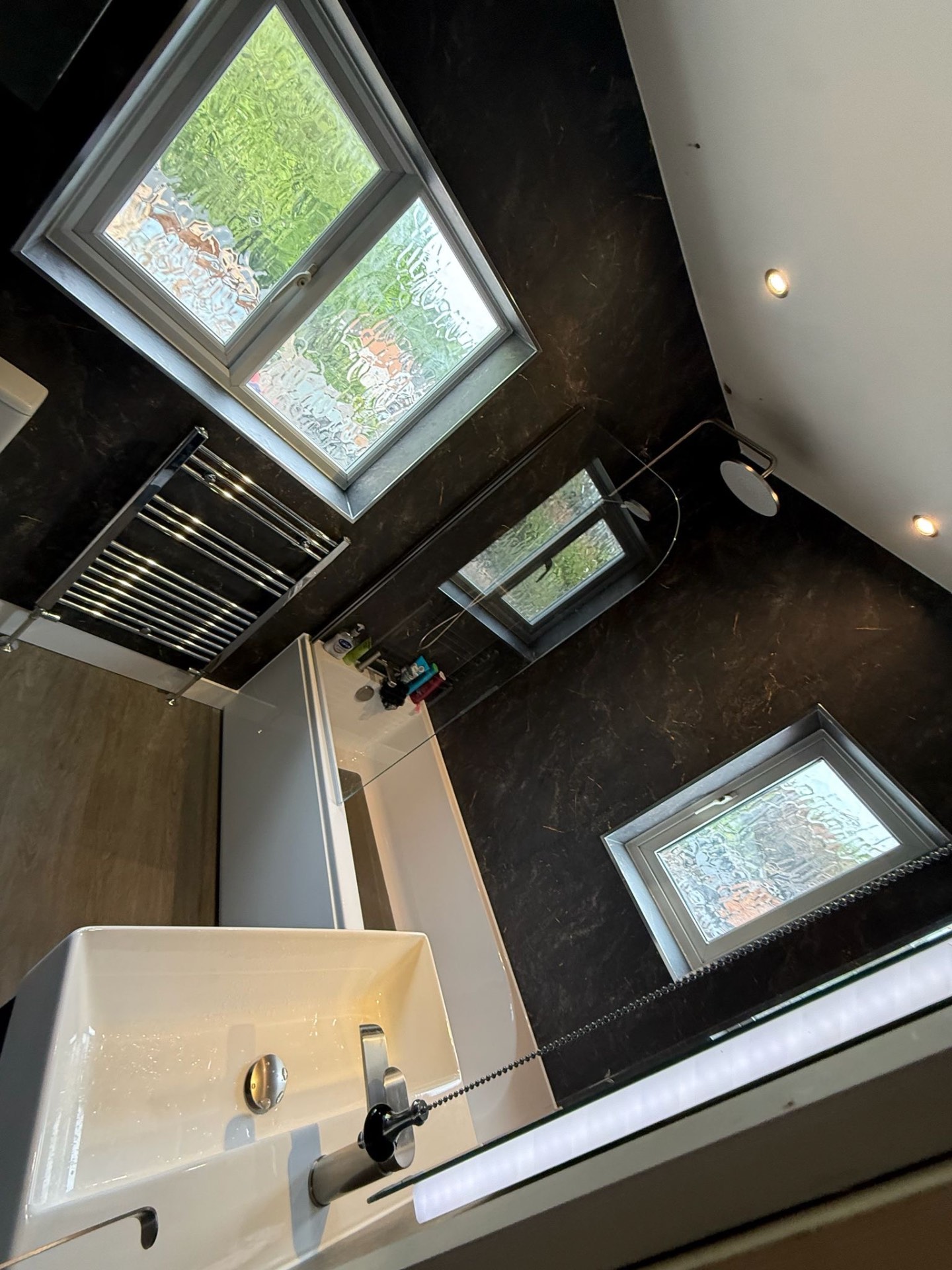 Black marble bathroom with countertop basin and LED mirror