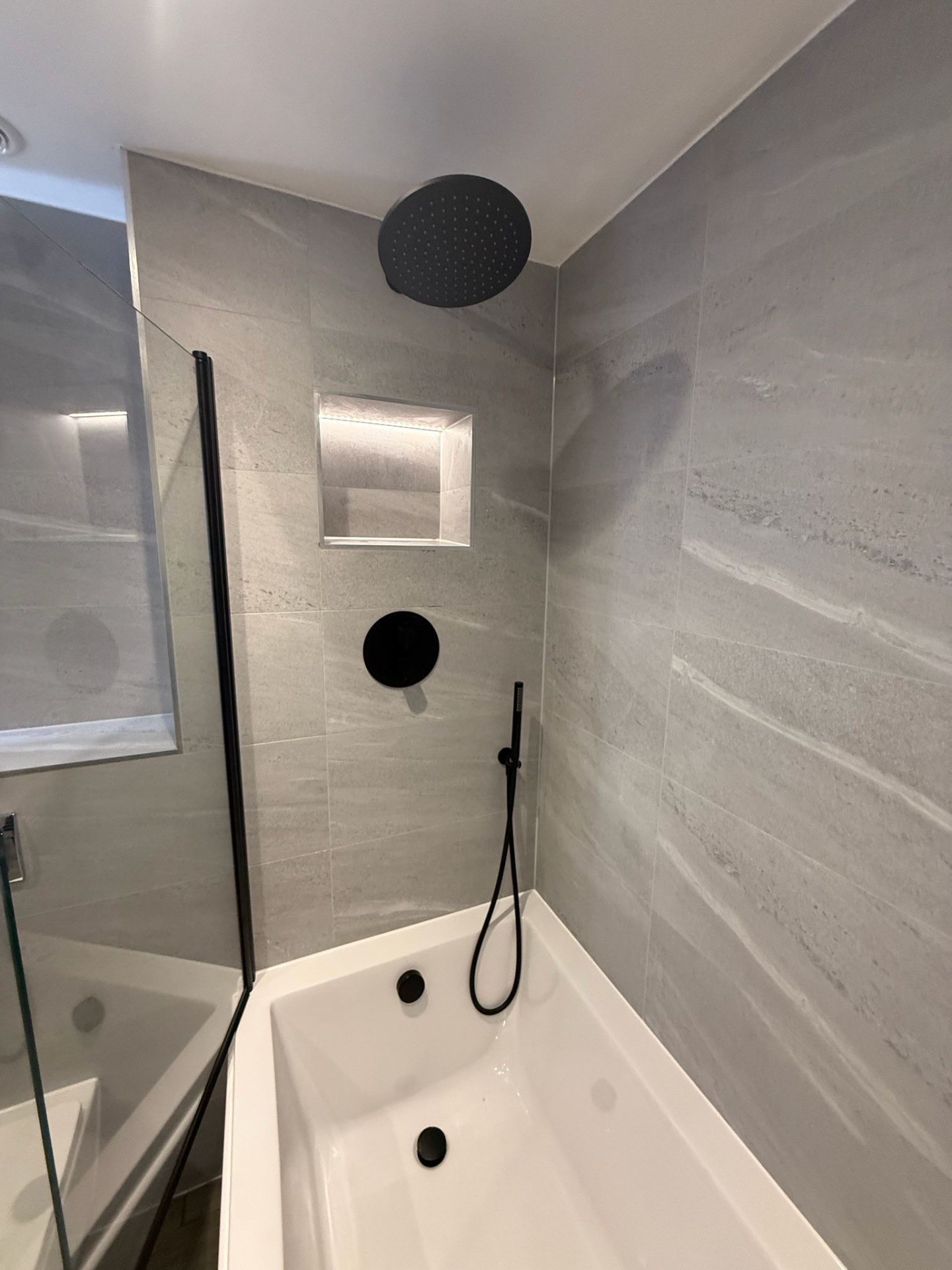 Black stone-effect shower room with rainfall shower and wall niche