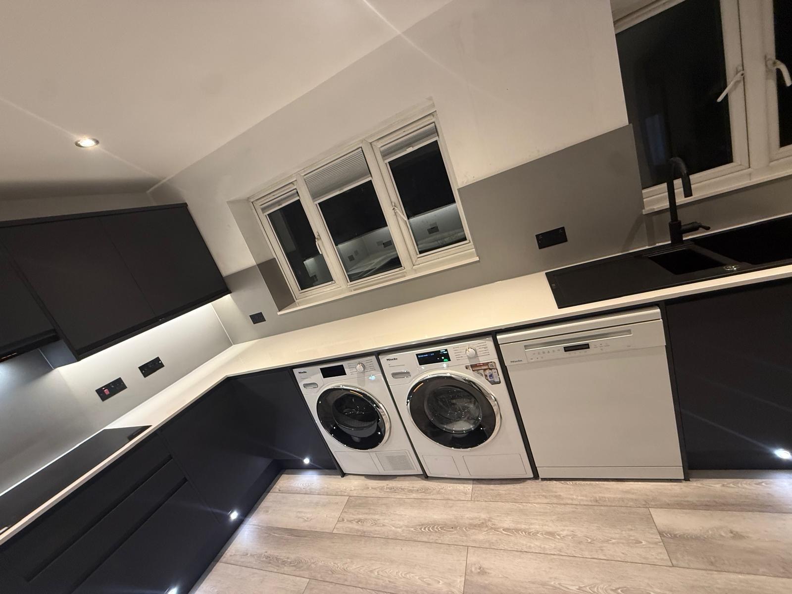 Contemporary dark fitted utility kitchen with laundry appliances