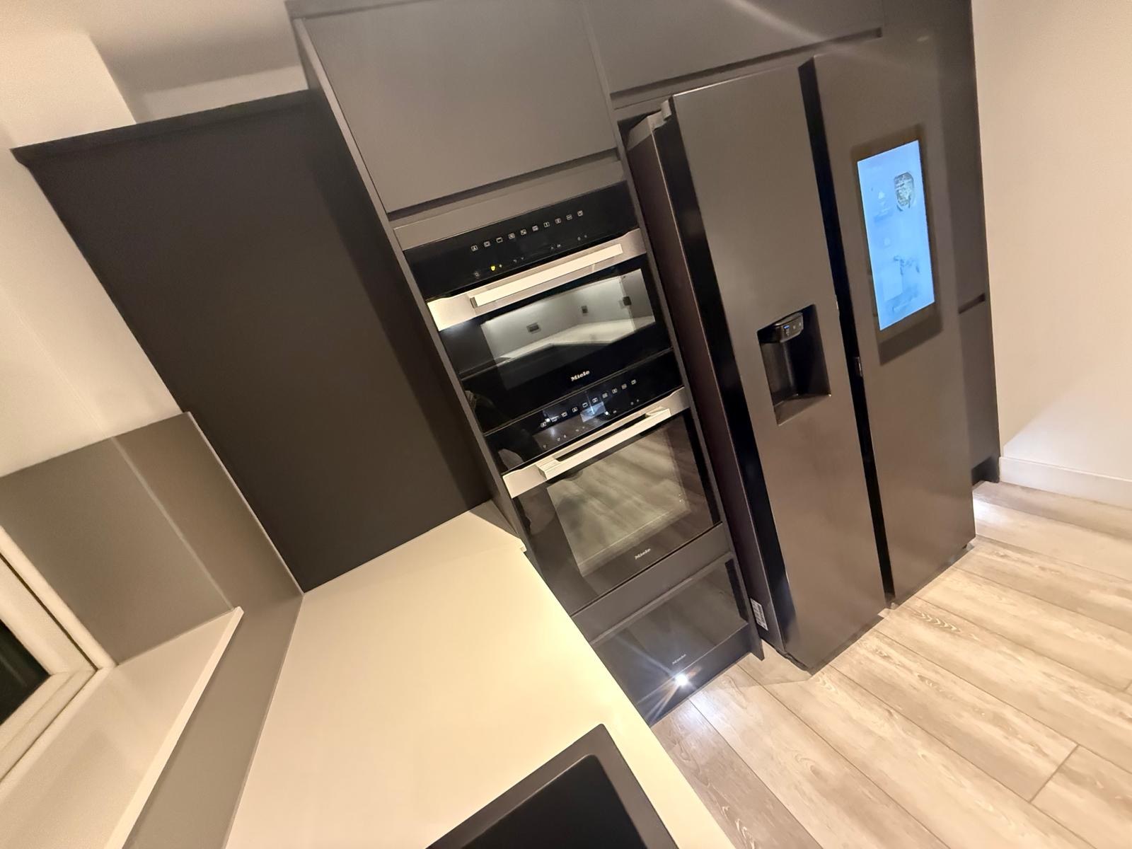 Close view of fitted kitchen cabinetry and integrated appliances