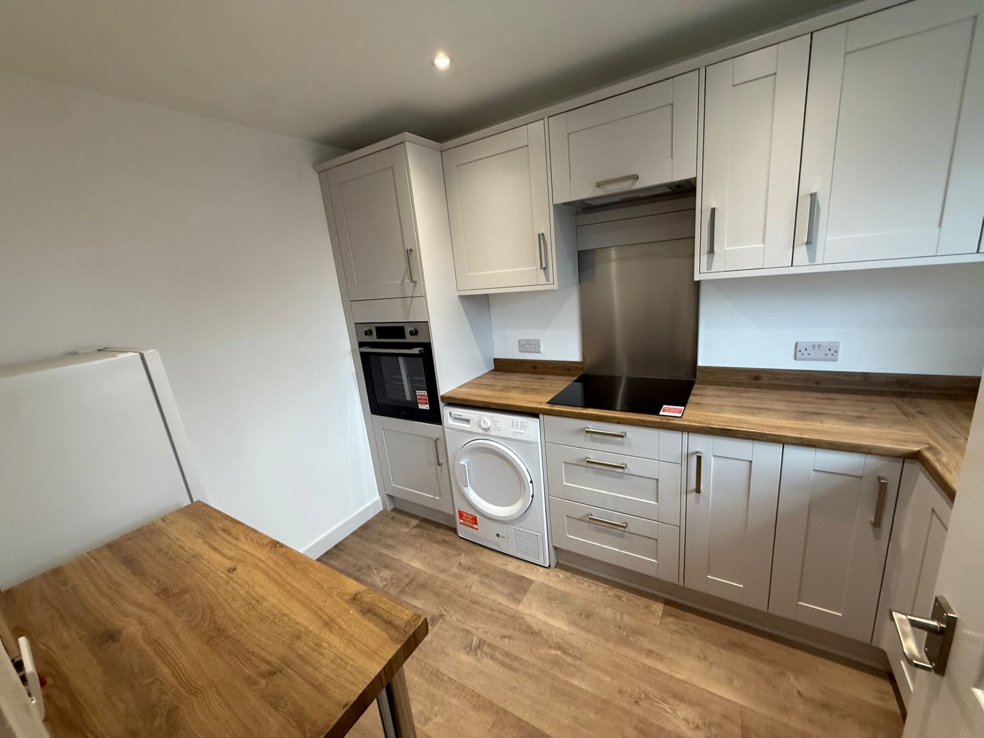 Grey Shaker kitchen with timber worktops and white wall cabinets